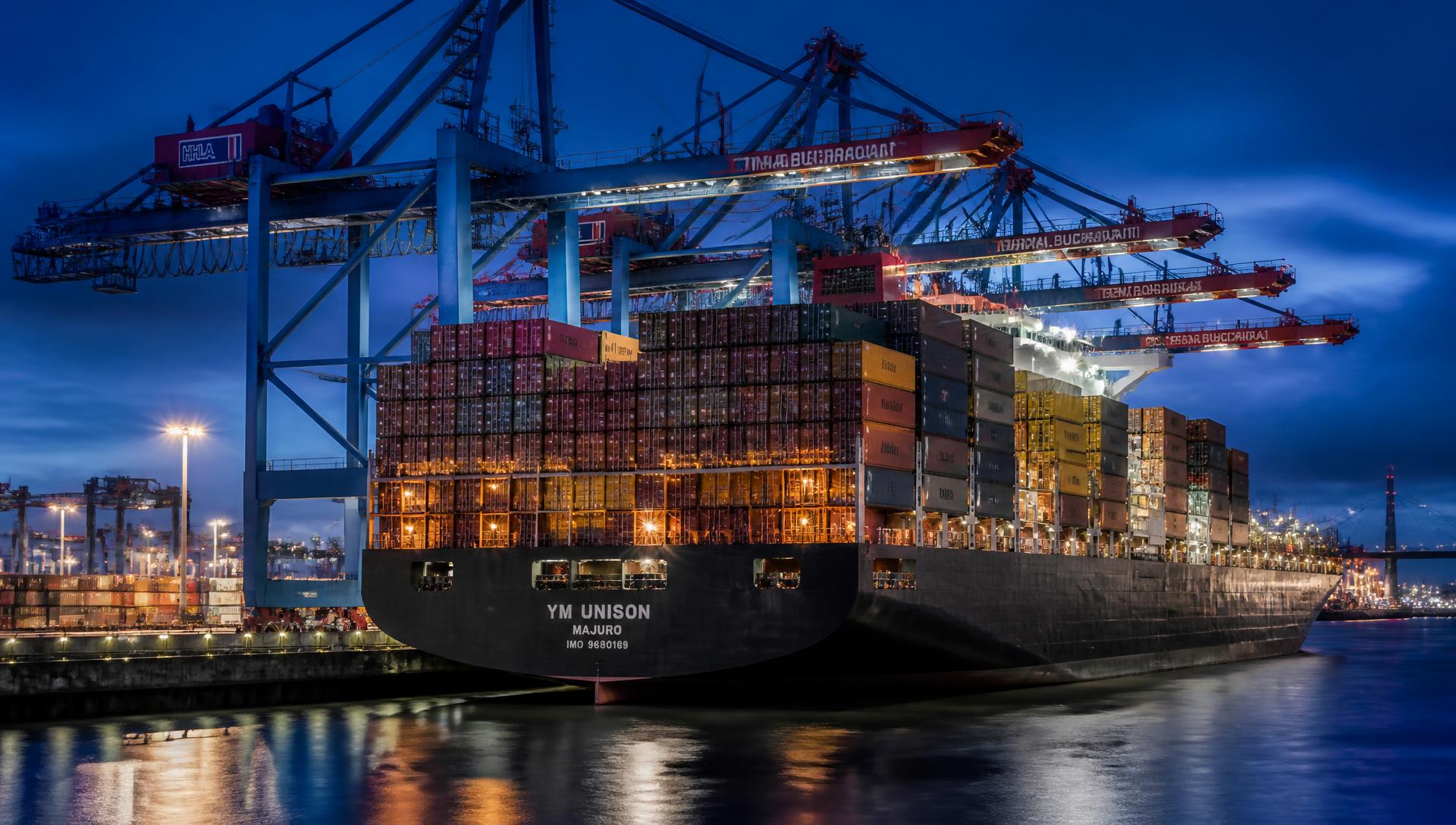 Container ship at a port terminal being loaded by gantry cranes
